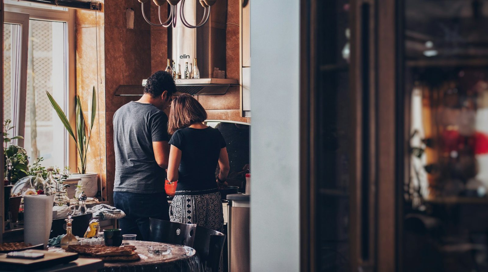 man and woman standing in front of gas range